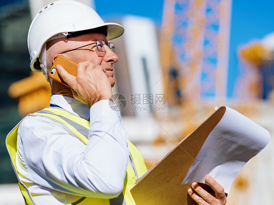 建筑工地的工程师建设者工程师建筑工人施工穿着安全背心记事本图片