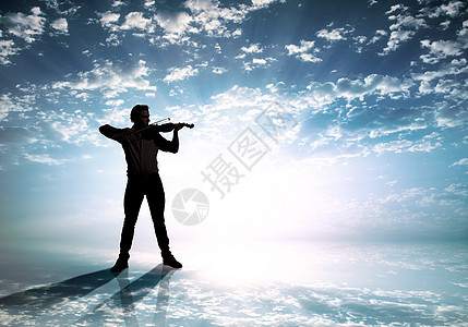 男小提琴手日落时拉小提琴的人的剪影图片