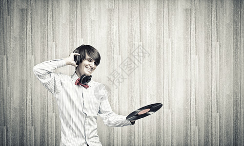 迪斯科DJ轻人DJ戴着耳机着盘子背景图片