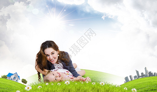 轻的家庭快乐的母亲女儿坐绿色的草地上图片