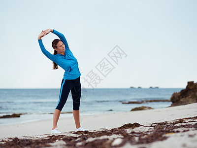 运动的轻女人海边伸展图片