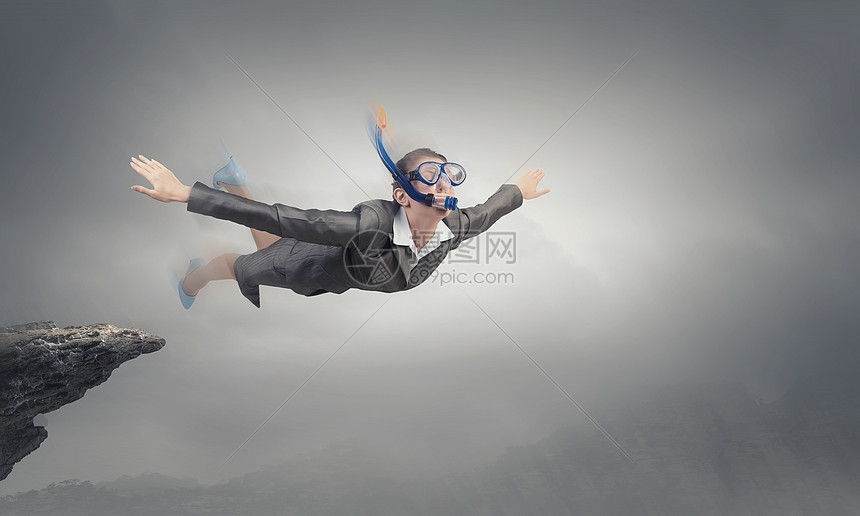 女商人潜水员穿着西装潜水具的轻女商人天空中飞翔图片