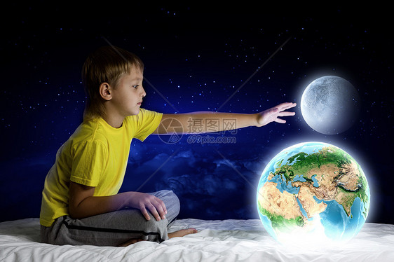晚上梦可爱的男孩坐床上抱着地球这幅图像的元素由美国宇航局提供的图片