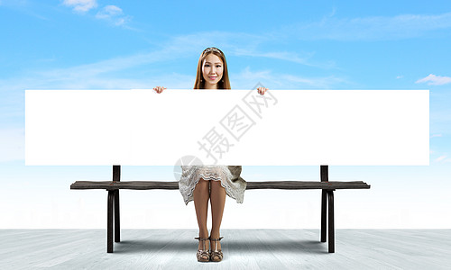 带横幅的女孩轻的亚洲女人坐长凳上,着空白的横幅图片