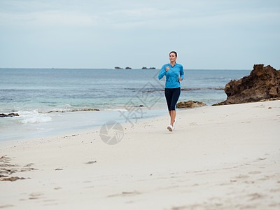 运动的轻女人海边跑步图片