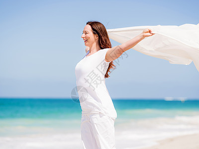 阳光明媚的天,海滩上穿着白色衣服的女人海滩上美好的天图片