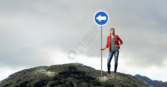 漂亮的女孩道路标志穿着红色夹克的轻女人着路标图片