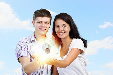 创造力的轻的幸福夫妇手捧电灯泡图片