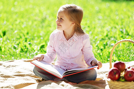 孩子带着书夏天的公园野餐公园里的女孩图片