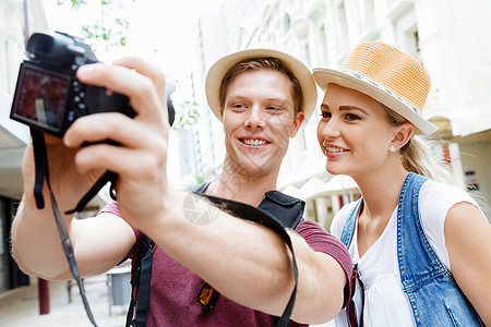 快乐的轻夫妇游客带着相机那将幅伟大的画图片