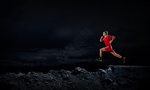 穿着红色运动服的跑步者穿着黑色背景全速前进图片