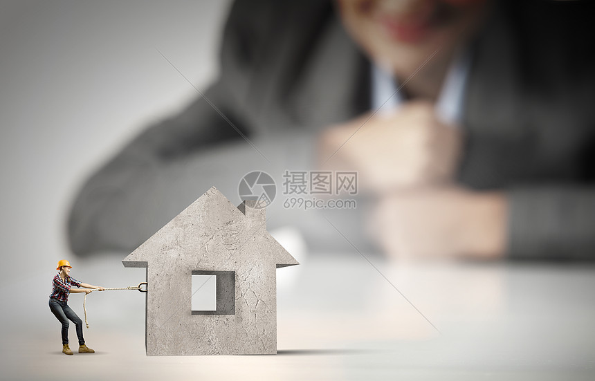 女建筑工人女商人看着建筑工人拉房子模型的缩影高清图片下载 正版图片 摄图网