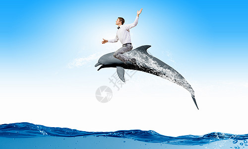 轻快乐的人骑着海豚跳水人类骑海豚图片