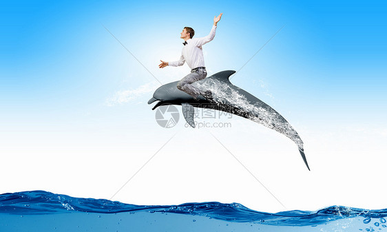 轻快乐的人骑着海豚跳水人类骑海豚图片