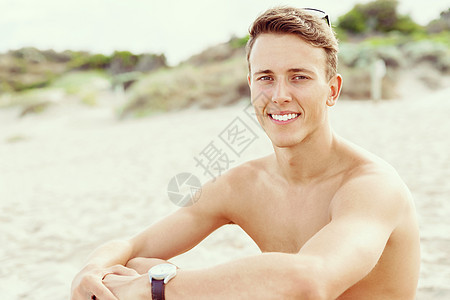 英俊的男人海滩上摆姿势阳光明媚的天,英俊的男人海滩上摆姿势的户外肖像图片