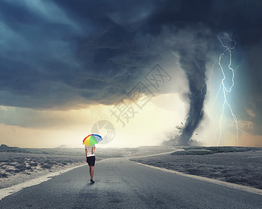 带彩虹伞的女人轻漂亮的女商人带着彩虹五颜六色的雨伞暴风雨中行走图片