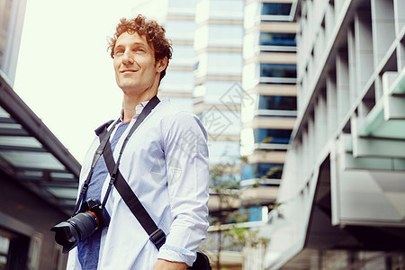 城市的男游客快乐的男游客穿着休闲服装城市与相机图片