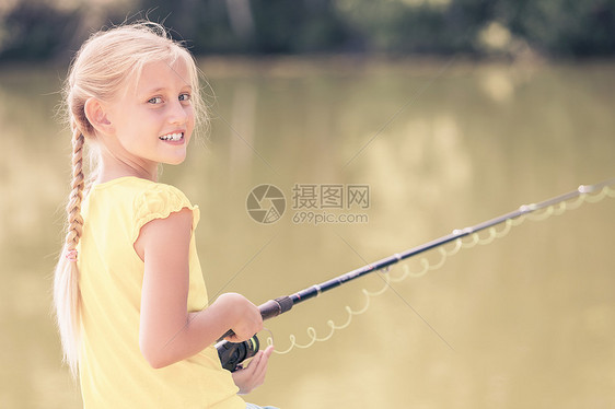 会钓大鱼的坐银行钓鱼的可爱女孩的肖像图片