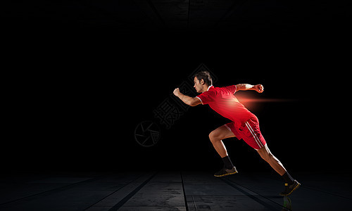 穿着红色运动服的跑步者穿着黑色背景全速前进图片