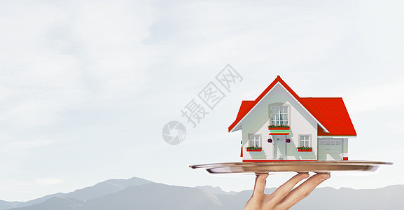 房地产报价服务员托盘上提供房屋模型的手图片