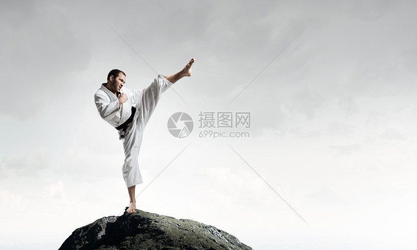 穿着白色基米诺的空手道男人轻坚定的空手道男子高空