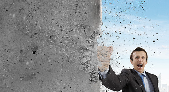 情感孤独克服挑战商人用空手道拳打破石墙背景