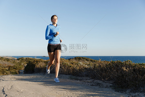 运动跑步者海滩上慢跑锻炼适合女健身模型沿海洋慢跑图片