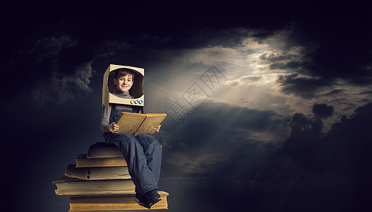 坐在书上看书会探索太空可爱的孩子,头上戴着纸箱头盔,梦想成为宇航员背景