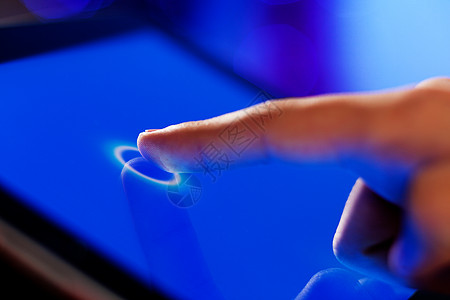 手指触摸屏幕手指触摸蓝色屏幕的特写图像图片