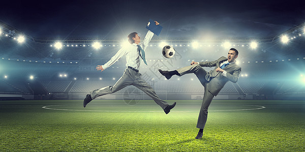 两个商人为球而战穿着西装的轻商人体育场踢足球图片