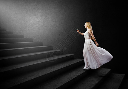 穿白色衣服的女人穿着白色长裙的轻女人走上楼梯图片