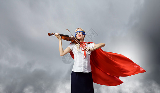 穿着超级英雄服装的轻女人拉小提琴图片