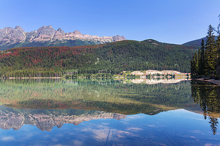 平静的景色加大的山湖旁边,岩石平静的水中反射图片