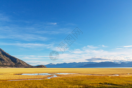 平静的景色加大的山湖旁边,岩石平静的水中反射图片