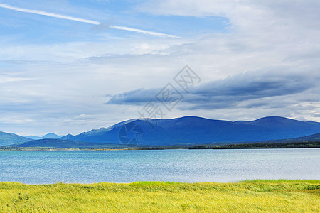 平静的景色加大的山湖旁边,岩石平静的水中反射图片