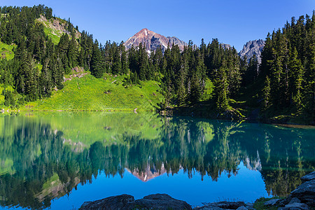 平静的景色山湖边,岩石平静的水中反射图片