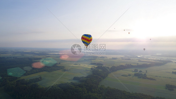 热气球飞过河流田野图片