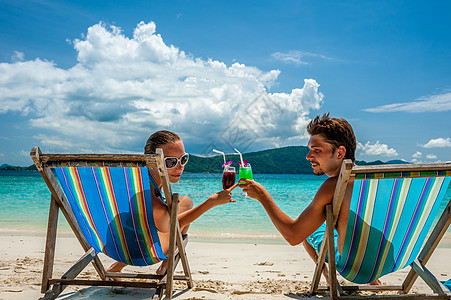 轻夫妇泰国的热带海滩上碰碰璃图片
