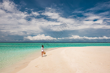 马尔代夫的热带海滩上戴着太阳帽的女人图片