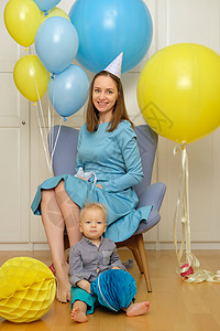 岁的小男孩岁生日蹒跚学步的孩子,妈妈坐椅子上,玩气球图片