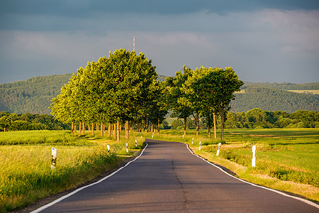 乡村道路的田野温暖的阳光下戏剧的天空,新鲜的充满活力的颜色,莱茵河谷莱茵峡谷德国图片