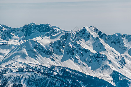 冬天的山景阳光明媚的日子里,高加索山脊上覆盖着雪克拉斯纳亚多拉那,索契,俄罗斯图片