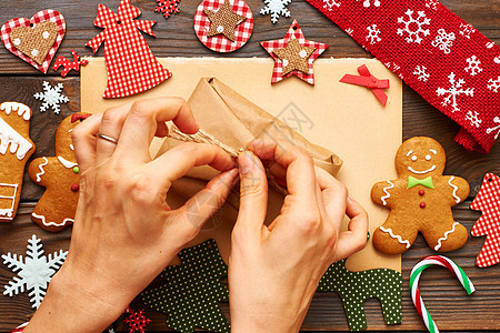 女手诞礼物自制姜饼饼干,手工装饰木制背景上图片