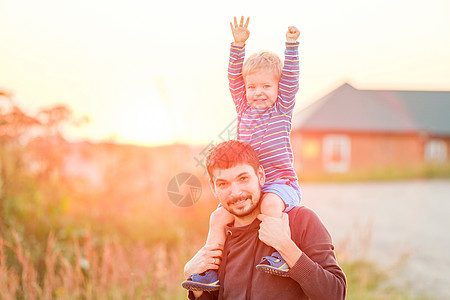 快乐的男人他的孩子户外玩得很开心家庭生活方式农村场景的父亲儿子夕阳的阳光下图片