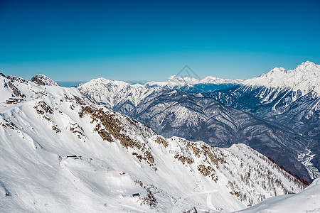 冬天的山景阳光明媚的日子里,高加索山脊上覆盖着雪克拉斯纳亚多拉那,索契,俄罗斯图片