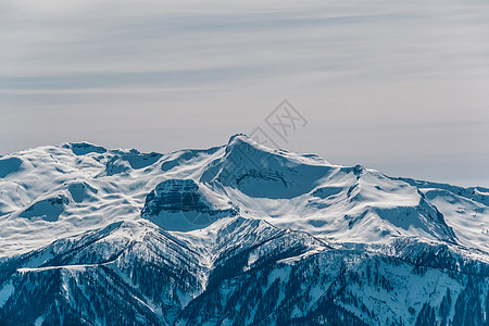 冬天的山景阳光明媚的日子里,高加索山脊上覆盖着雪克拉斯纳亚多拉那,索契,俄罗斯图片