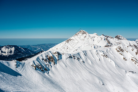 冬天的山景阳光明媚的日子里,高加索山脊上覆盖着雪克拉斯纳亚多拉那,索契,俄罗斯图片