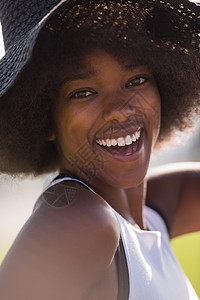 特写位美丽的轻非裔美国妇女的肖像,微笑着仰望个美丽的阳光明媚的日子图片