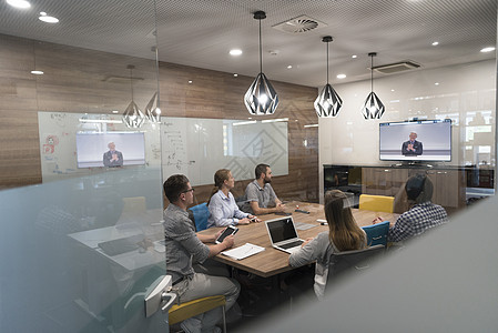 开办企业人员小参加视频会议电话与高级投资者现代办公室背景图片