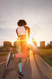 轻的黑人女孩慢跑美丽的早晨,太阳升城市的街道上图片